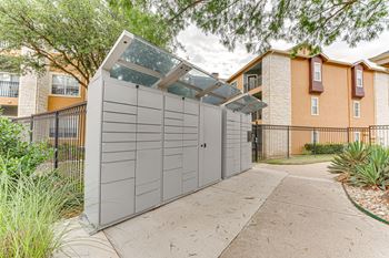 A modern garage with a glass roof is situated in front of a residential building at Limestone Ranch Apartments, Lewisville 75067